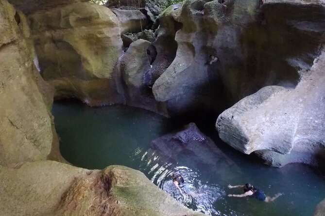 Cave Adventure - Charco Azul Caves, Canyon & Waterfall Adventure - Hiking through wet rainforest terrain