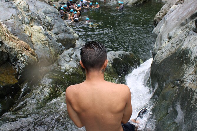 Small-Group El Yunque Waterslide Adventure & transportation - Sliding, swinging, and jumping in the river